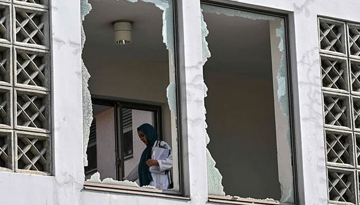 A medical staff member walks past a damaged corridor at the site, a day after a fire at the Mother and Child Health ward of the Pakistan Institute of Medical Sciences (Pims) Hospital in Islamabad on August 27, 2026. — AFP