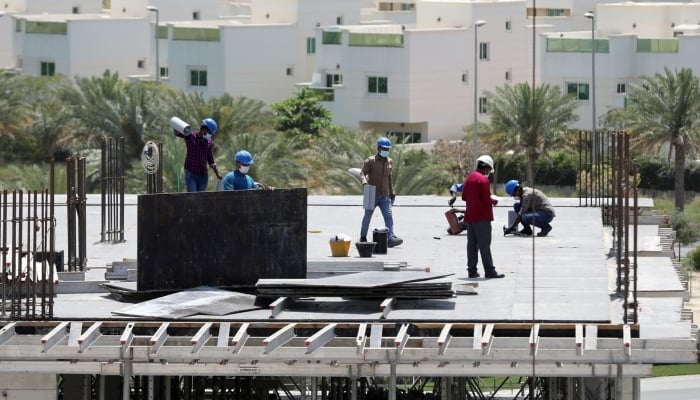 Workers wearing protective face masks work on a residential construction site in Dubai, United Arab Emirates, April 14, 2020. — Reuters