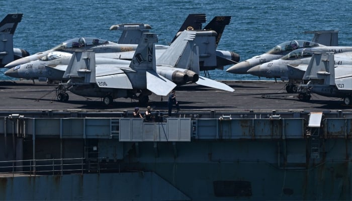 Crew members are seen next to aircrafts on the flight deck of the US aircraft carrier USS Abraham Lincoln (CVN-72) departing Laem Chabang Port, near the city of Pattaya on September 6, 2026. — AFP