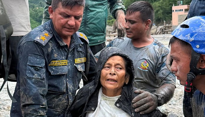 Nepal Police officers assist Chandika Kumari Shrestha after she was rescued alive from a damaged house following deadly flash floods and mudslides, in Betrawati in Nuwakot district, Nepal, September 5, 2026. — Reuters