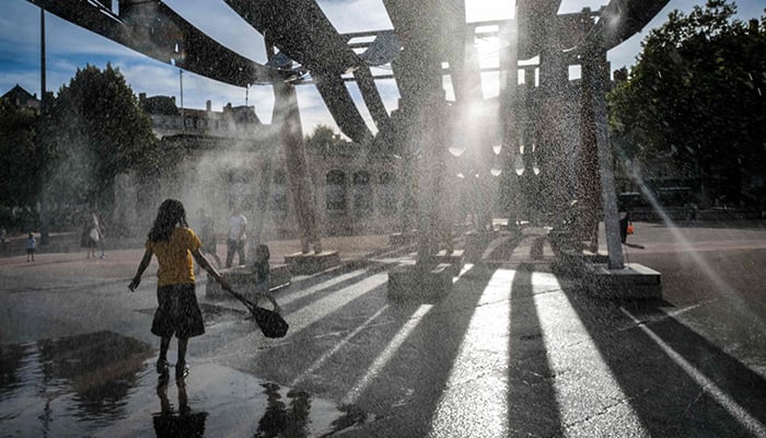 Pedestrians walk through water sprays on Place Bellecour during a heatwave in Lyon, central France on September 2, 2026. — AFP