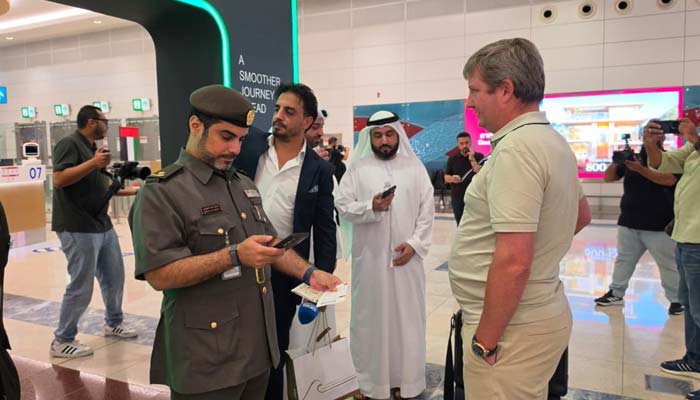 A Dubai immigration officer checks a traveller’s documents as the emirate launches a seconds-fast immigration system to speed up airport processing. — Reporter