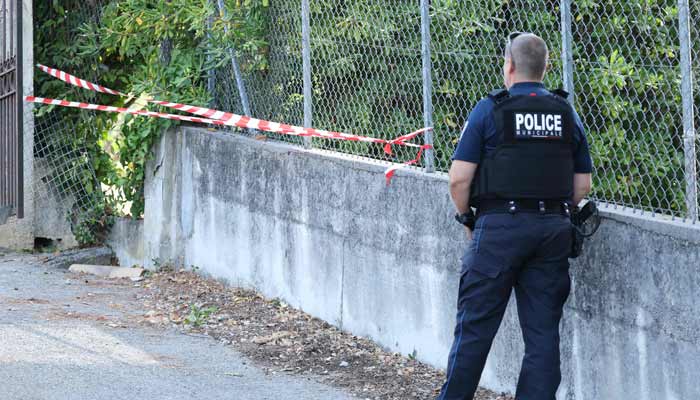 A police officer stands near a hole cut by the thieves in the outer fence of the Musee Renoir after four paintings, together valued at nine million euros, were stolen in an early-morning break-in, with one recovered nearby and two suspects still at large, in Cagnes-sur-Mer on September 8, 2026.— AFP