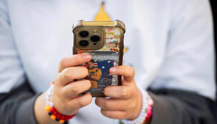 A teenage poses while holding a mobile phone, in Sydney, Australia July 14, 2026. — Reuters