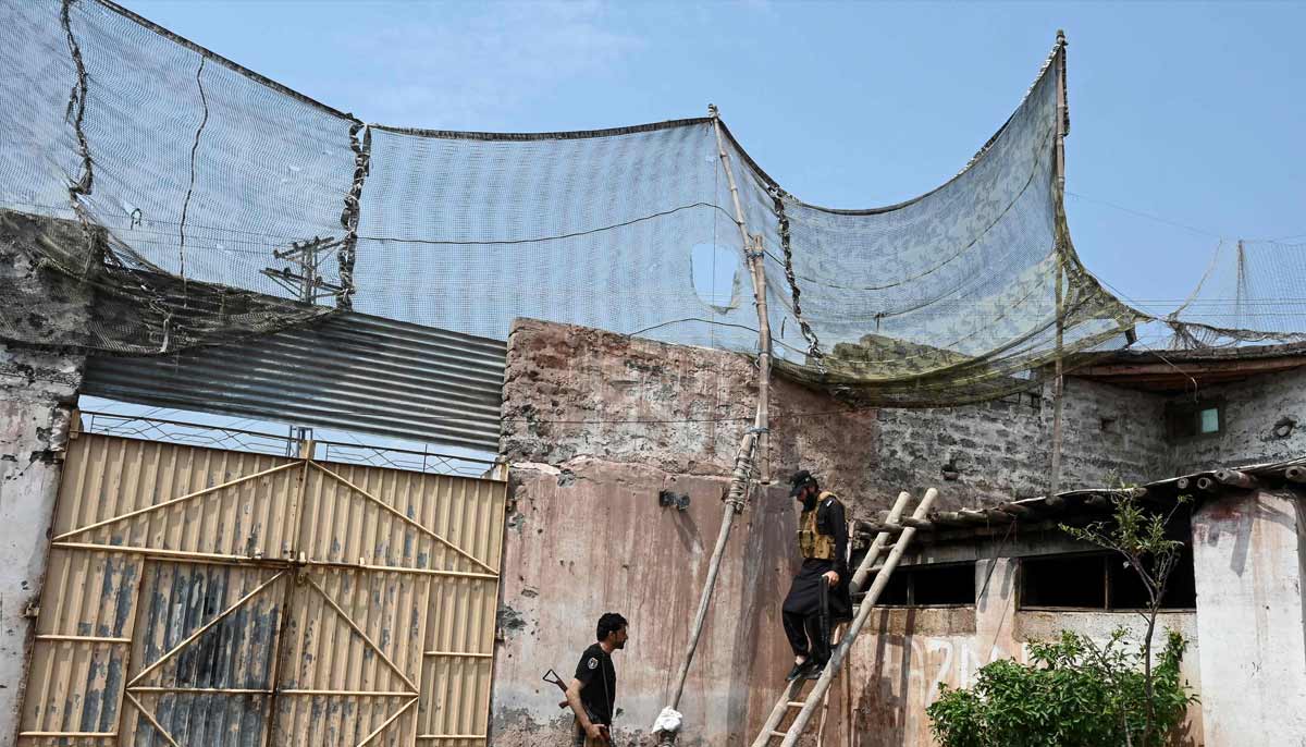 A security personnel climbing down a ladder after fortifying a police post with Ukraine-style mesh barriers, as a new line of defence against militant drone and aerial attacks in Khyber Pakhtunkhwa. — AFP