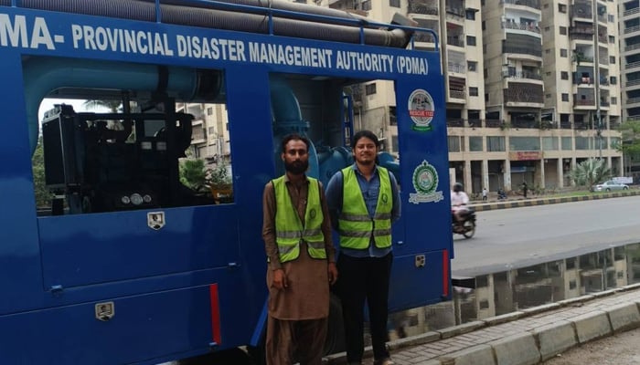 Sindh Provincial Disaster Management Authority officials stand beside a mobile dewatering pump vehicle in Karachi on June 28, 2025. — Facebook/@PDMA.Sindh