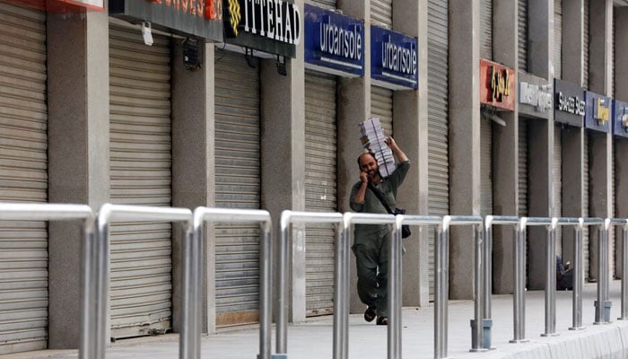 A man walks past a closed market during a partial lockdown after Sindh provincial government decided to shut markets in Karachi, on July 30, 2021. — Reuters