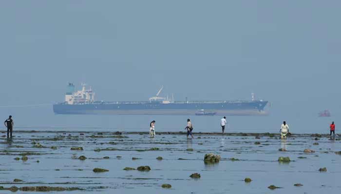 Tourists watch marine life, with the MT Desert Kite oil tanker carrying Russian oil in the background, at Narara Marine National Park in the Arabian Sea, Gujarat, India, March 11, 2026.— Reuters
