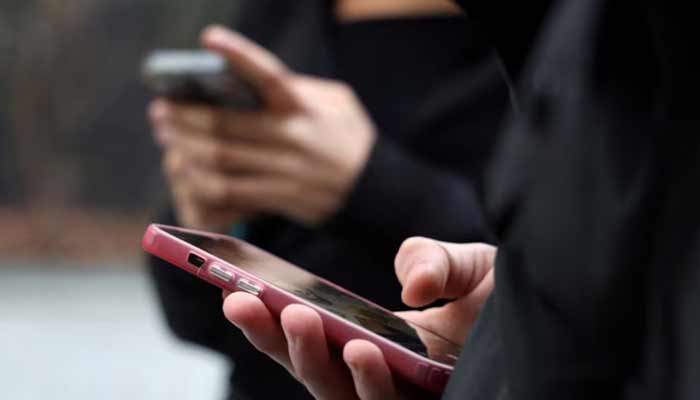 Teenagers look at their mobile phone screens during an interview with Reuters about the bill aimed at banning the use of social networks for those under 15 and mobile phones in high schools from the start of the 2026 school year, in Paris, France, February 20, 2026.— Reuters