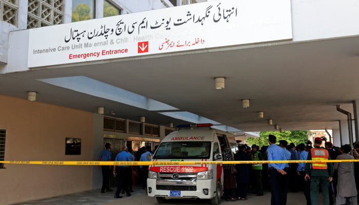 Police officers move past an ambulance outside an intensive care unit after a fire broke out at the Pakistan Institute of Medical Sciences hospital in Islamabad, August 26, 2026. — Reuters