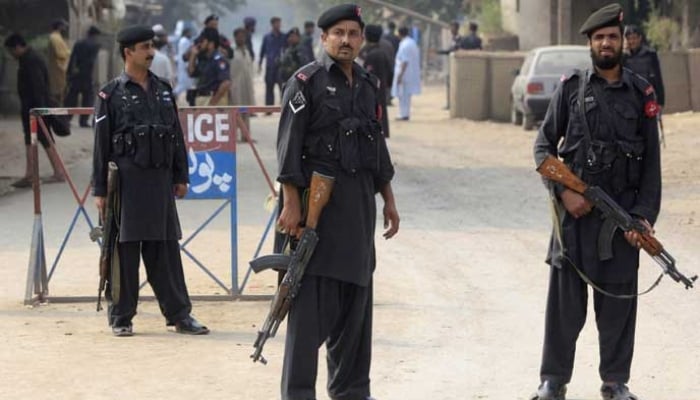 Police personnel in Khyber Pakhtunkhwa stand guard near a barricade on a road. — Reuters/File