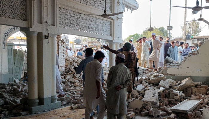 People gather at a damaged mosque following a suicide attack at a police facility in Kohat, September 18, 2026. — Reuters