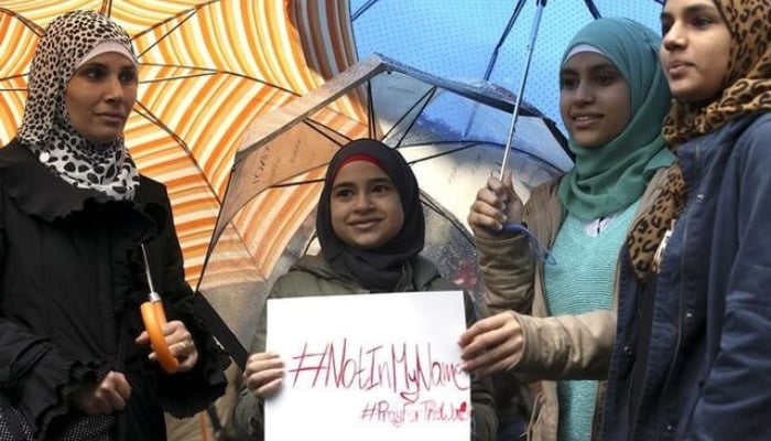 Women hold a placard during a demonstration called Not in my name of Italian muslims against terrorism, in downtown Rome, Italy, November 21, 2015. — Reuters