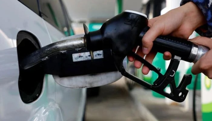 A person uses a fuel nozzle to fuel up a car at a petrol station in Vienna, Austria. — Reuters/File