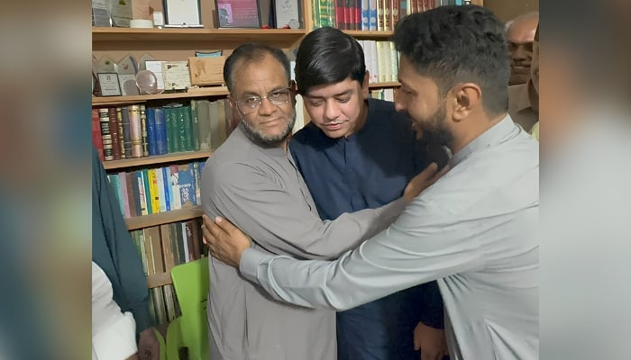 University of Karachi Professor Arif Khan Saqi (left) embraces Konain Shah (centre right) at his home, on September 20, 2026. — Reporter
