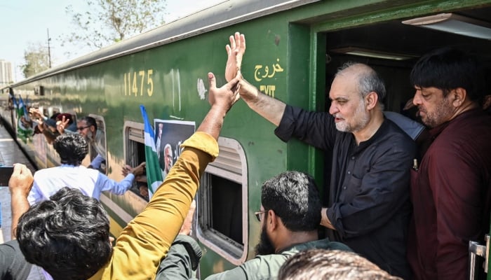 The Jamaat-e-Islami party chief Hafiz Naeem Ur Rehman (2R) waves to supporters as he starts a train march towards the countrys capital Islamabad against the increased petroleum levy, rising fuel prices and inflation, at a railway station in Karachi on September 20, 2026. — AFP