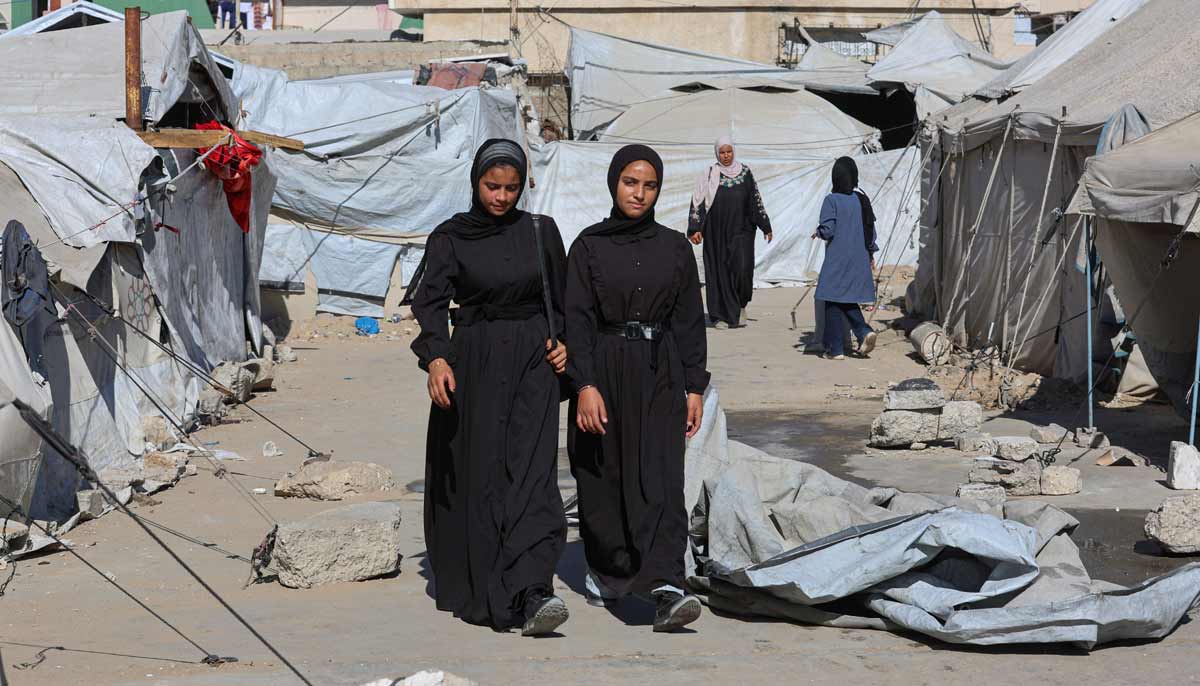 Displaced Palestinian student Samar Abu Salmi, 15, walks with a classmate through a tent camp on her way to school in Khan Younis, in the southern Gaza Strip, September 20, 2026.— Reuters
