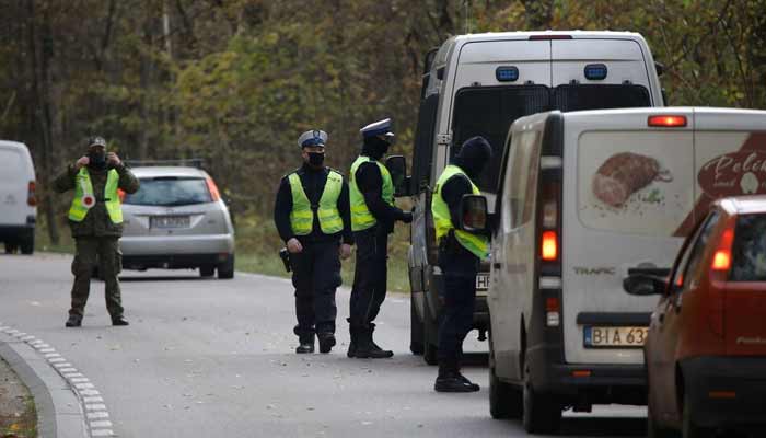 Polish police officers examine vehicles at a checkpoint on entry to the prohibited state of emergency zone. — Reuters/File