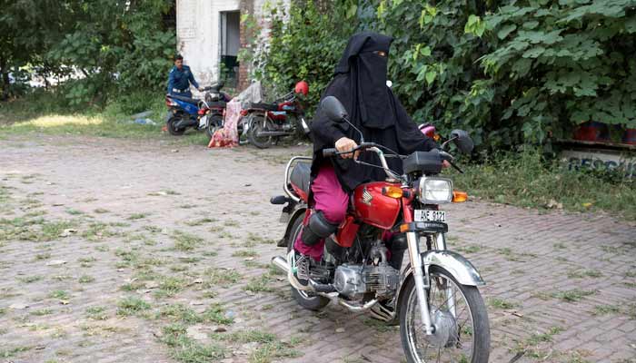 A woman rides a motorbike during a motorbike training session organised by the traffic police department in Lahore. — Reuters