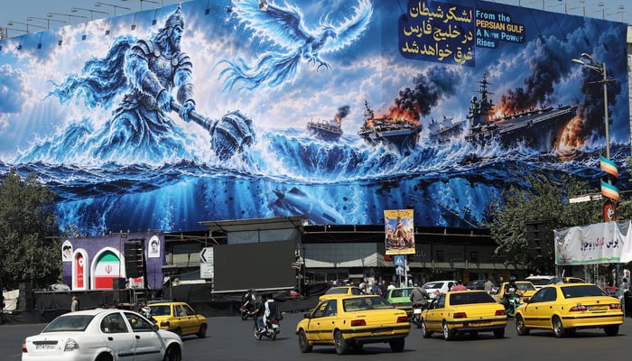 People drive past a billboard about the Strait of Hormuz, on a building in Tehran, Iran, September 16, 2026. — Reuters