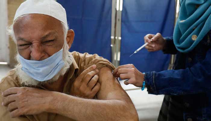 The image shows a man receives a dose of vaccine — Reuters/File