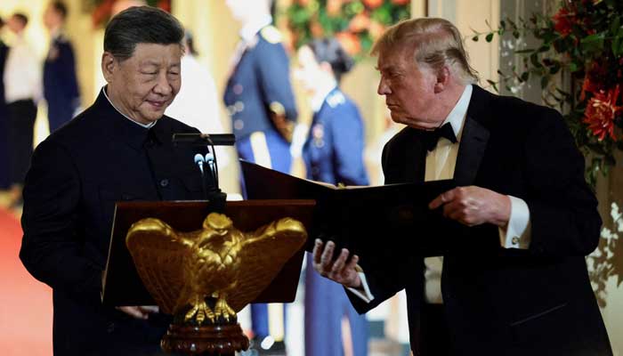 US President Donald Trump holds a binder as he stands next to Chinese President Xi Jinping before Xi delivers a speech during a state dinner at the White House in Washington, DC, US, September 24, 2026. — Reuters