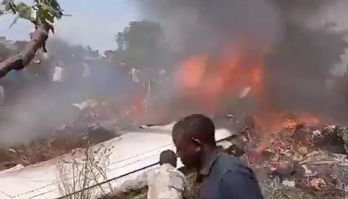Rescue workers can be seen at the crash site of a Let 410 UVP aircraft operated by Tracep Congo Aviation. — X/@RaoAmarenda