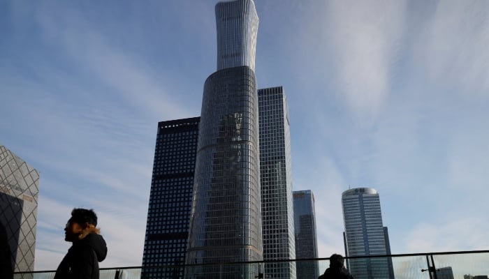 Men stand on a balcony overlooking the central business district in Beijing, China. — Reuters/ File
