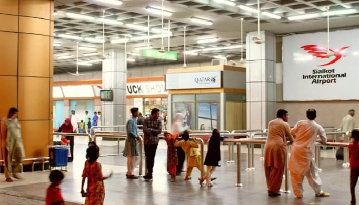 People stand by an exit at Sialkot International Airport in Sialkot. — Online/File