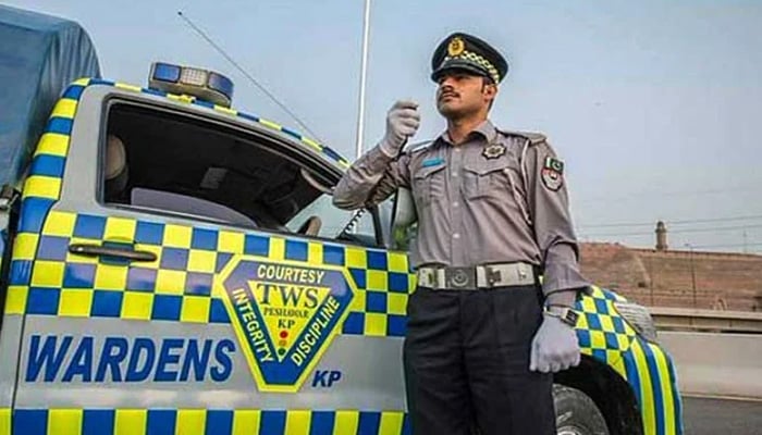 A Khyber Pakhtunkhwa Traffic Police warden speaks into his wireless radio system while stationed on patrol duty. — Khyber Pakhtunkhwa Directorate General Information/File