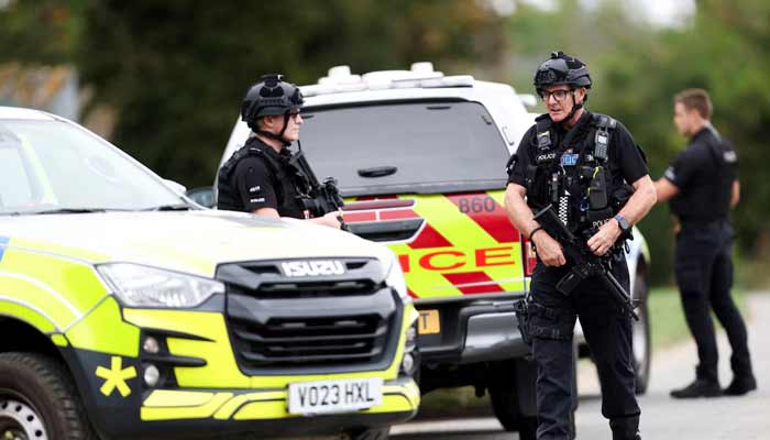 Armed police officers work on a road outside the perimeter of the RAF Fairford airbase, after police declared a major incident at the base after several men were arrested on suspicion of offences under the Explosives Act, in Fairford, Gloucestershire, Britain, September 27, 2026.— Reuters