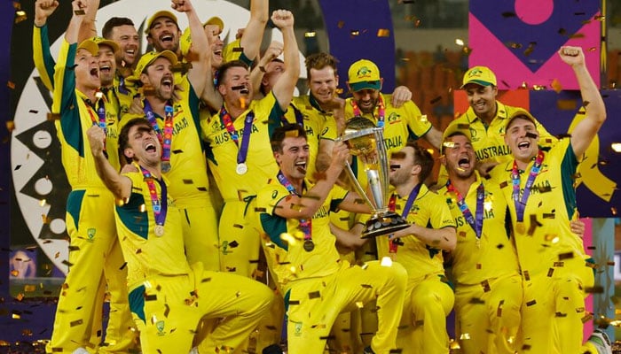 Australias Pat Cummins celebrates with the trophy and teammates after winning the ICC Cricket World Cup at Narendra Modi Stadium, Ahmedabad, India on November 19, 2023. — Reuters