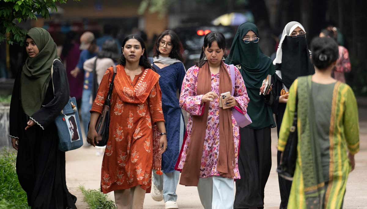 Image shows Dhaka University students walking across the campus in Dhaka.— AFP