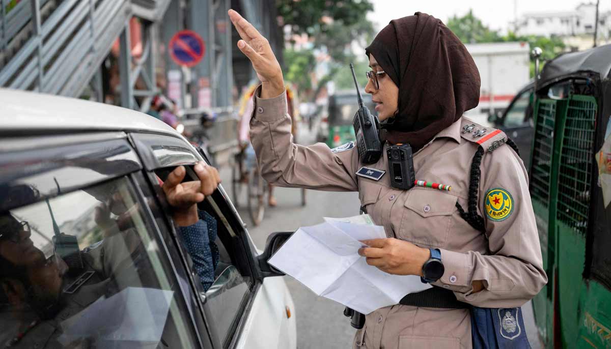 Nipa Khatun, a traffic sergeant issuing a traffic violation ticket to a driver in Dhaka.— AFP