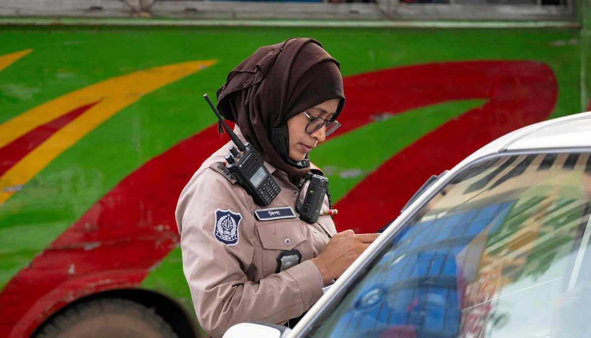 Nipa Khatun, a traffic sergeant issuing a traffic violation ticket to a driver in Dhaka.— AFP