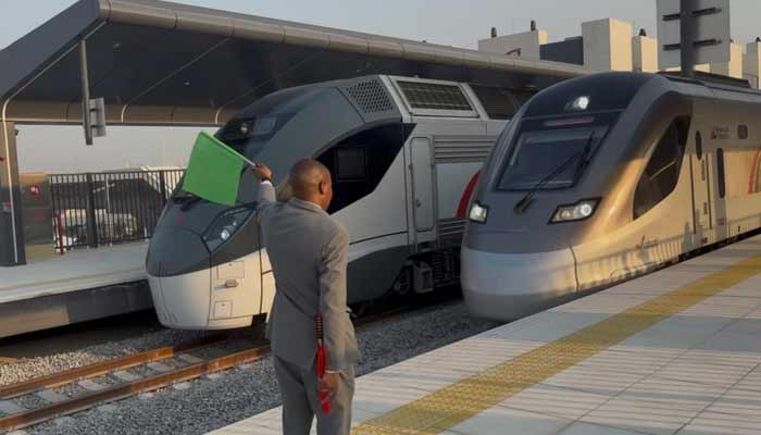 A train guard waving flag, signalling the train to pass during the launch ceremony of Etihad Rail, United Arab Emirates, September 30th, 2026. — Geo News