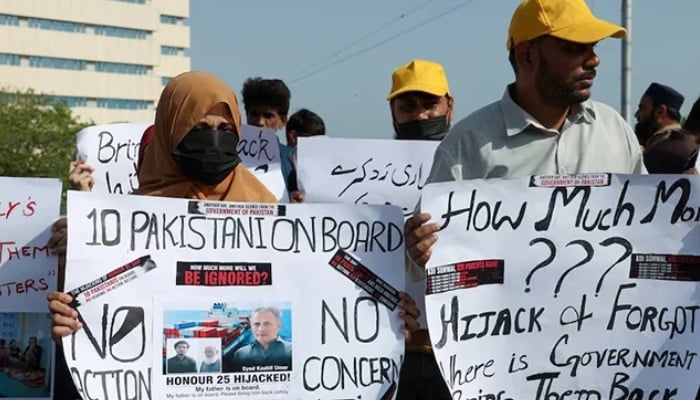 Families of the Pakistani hostage crew members of HONOUR 25 that was hijacked by pirates off the coast of Somalia, hold placards during a protest, calling the government to take immediate action for the safe return of their loved ones, in Karachi, May 13, 2026. — Reuters