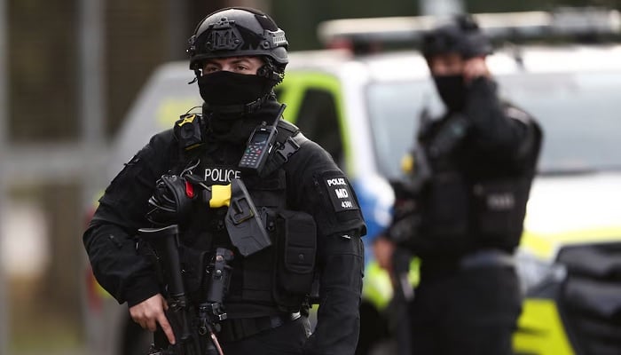 An armed police officer stands guard on a road in Fairford, Gloucestershire, Britain, September 28, 2026. — Reuters