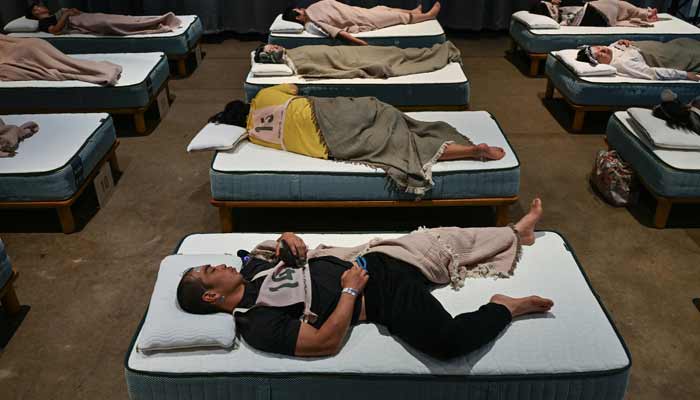 Attendees take part in a sleep competition organized by a mattress brand in Tokyo on October 5, 2026.— AFP
