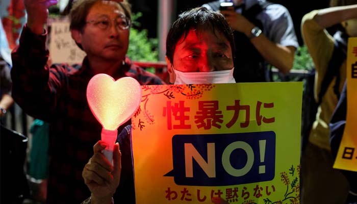 A demonstrator holds a placard during a protest outside the Prime Ministers office following the killing of a Japanese woman in Okinawa, for which a US Marine is a suspect, in Tokyo, Japan, October 5, 2026. — Reuters