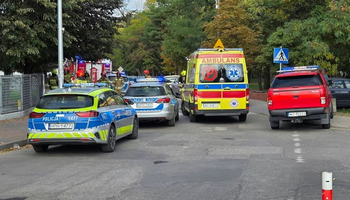Emergency personnel stand next to vehicles outside a school, following a stabbing attack injuring several, in Ostroleka, Poland, October 7, 2026, in this picture obtained from social media. — Reuters