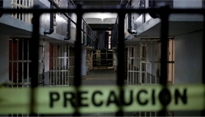 The image shows a cellblock corridor inside Topo Chico prison in Monterrey, Mexico, draped with yellow police caution tape (PRECAUCION). — Reuters/File
