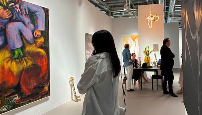 Visitors look at an artwork displayed at Art Basel, in Basel, Switzerland, June 17, 2026. — Reuters