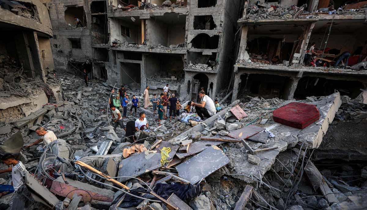 People search the rubble of a collapsed building following overnight Israeli airstrikes in Gaza City on October 9, 2026. — AFP