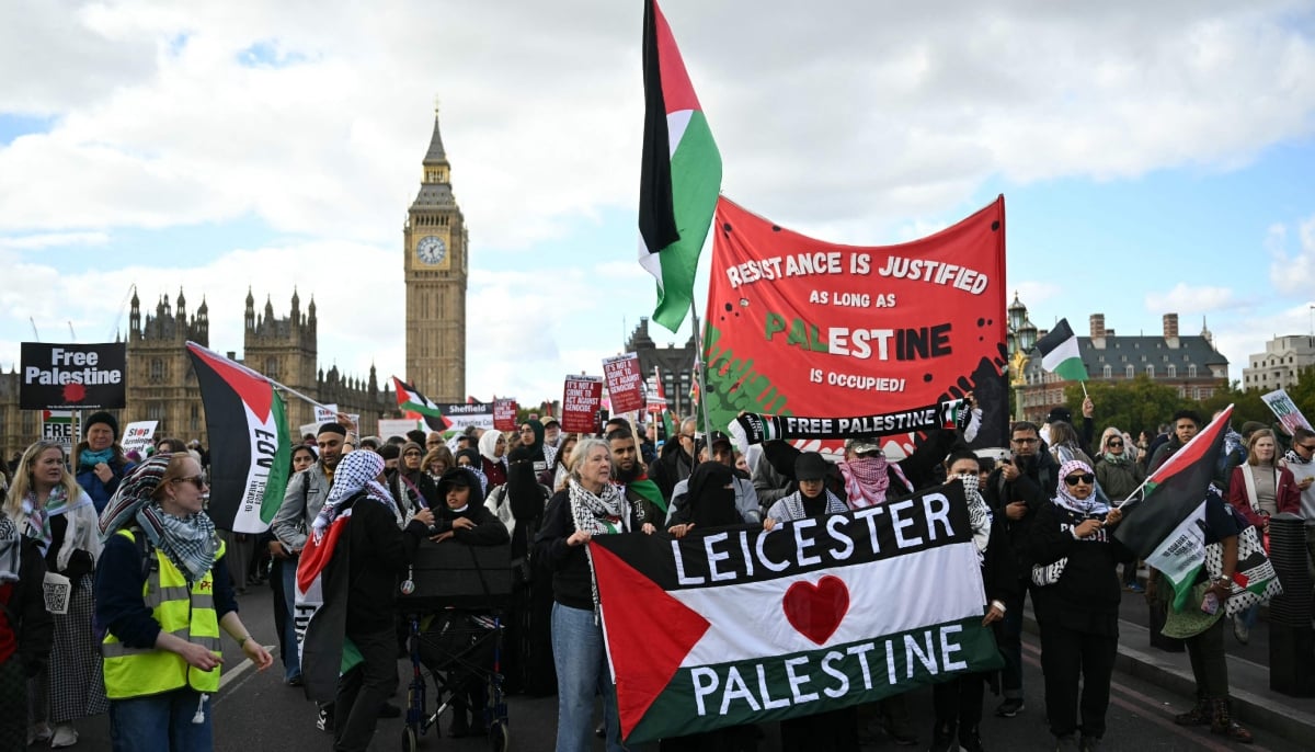People cross Westminster Bridge with banners as they take part in a National March in support of Palestine, organised by Palestine Solidarity Campaign, in central London on October 10, 2026. — AFP