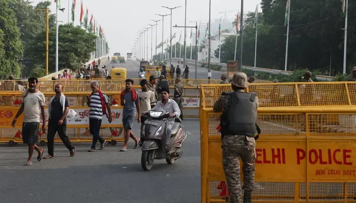 Commuters cross a checkpoint as police officers stand guard on the second day of a protest planned by the Cockroach Janta Party (CJP) seeking the resignation of Indias Chief Election Commissioner, Gyanesh Kumar, in New Delhi, India, October 11, 2026. — Reuters