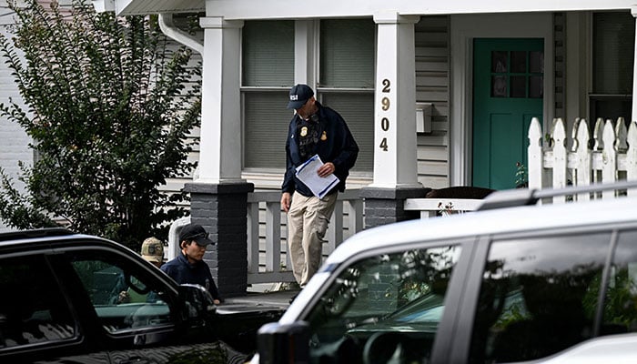 Agents of the Homeland Security Investigations (HSI) work at the entrance of the residence of US Rep Ilhan Omar (D-MN), after US authorities conducted a raid as part of an ongoing investigation by the Justice Department, in Washington, DC, US, October 12, 2026. — Reuters