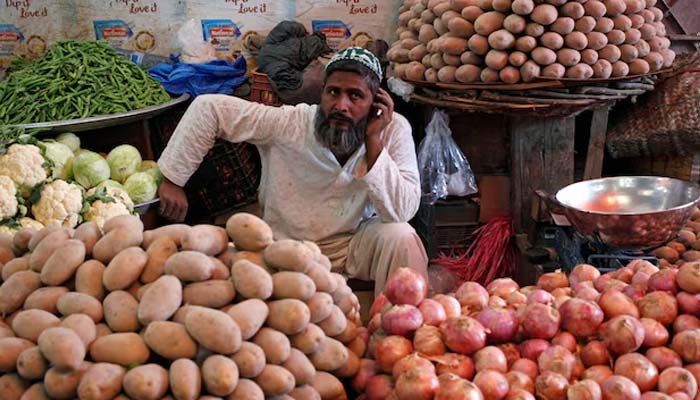A man selling vegetables waits for customers at his makeshift stall at the Empress Market in Karachi, April 2, 2018. — Reuters