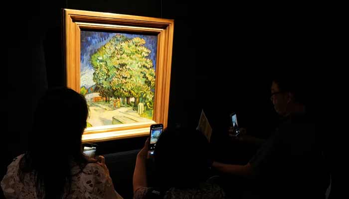 Visitors look at Vincent van Goghs Chataigniers en fleurs (Chestnut Trees in Blossom), on display ahead of its auction in New York, at Sothebys in Hong Kong, China, October 13, 2026.— Reuters