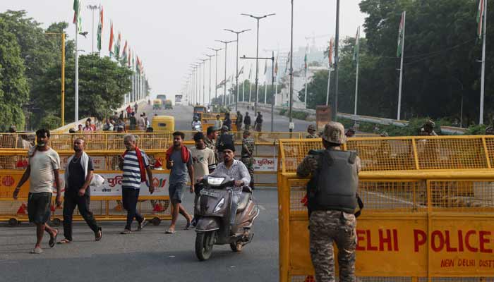 Commuters cross a checkpoint as police officers stand guard on the second day of a protest planned by the Cockroach Janta Party (CJP) seeking the resignation of Indias Chief Election Commissioner, Gyanesh Kumar, in New Delhi, India, October 11, 2026. — Reuters